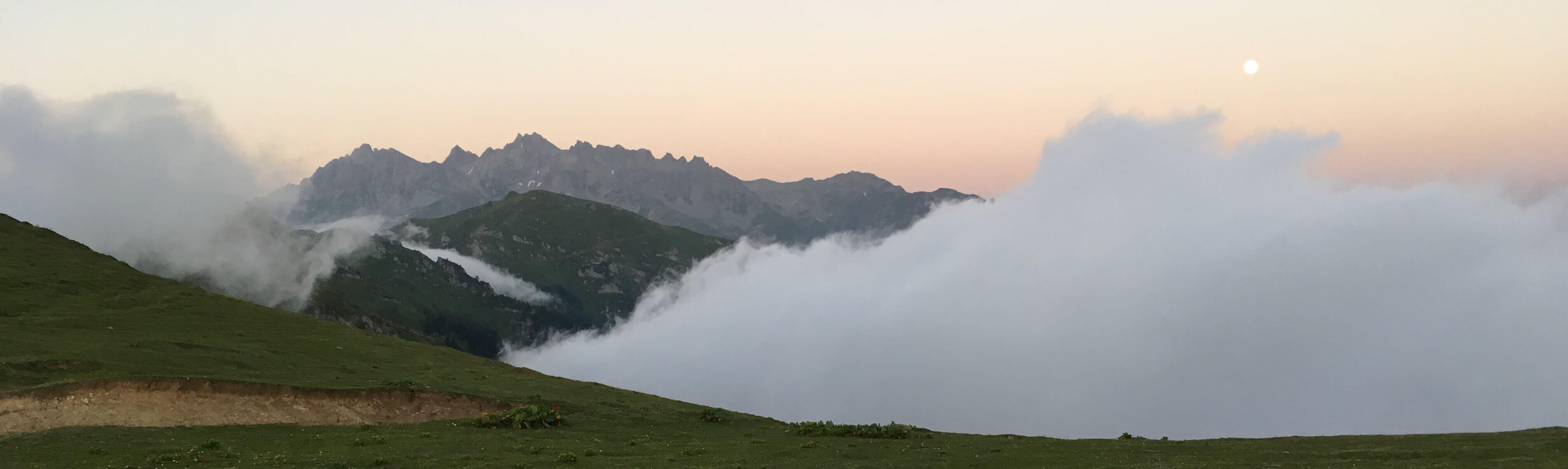 a full moon over mountain clouds